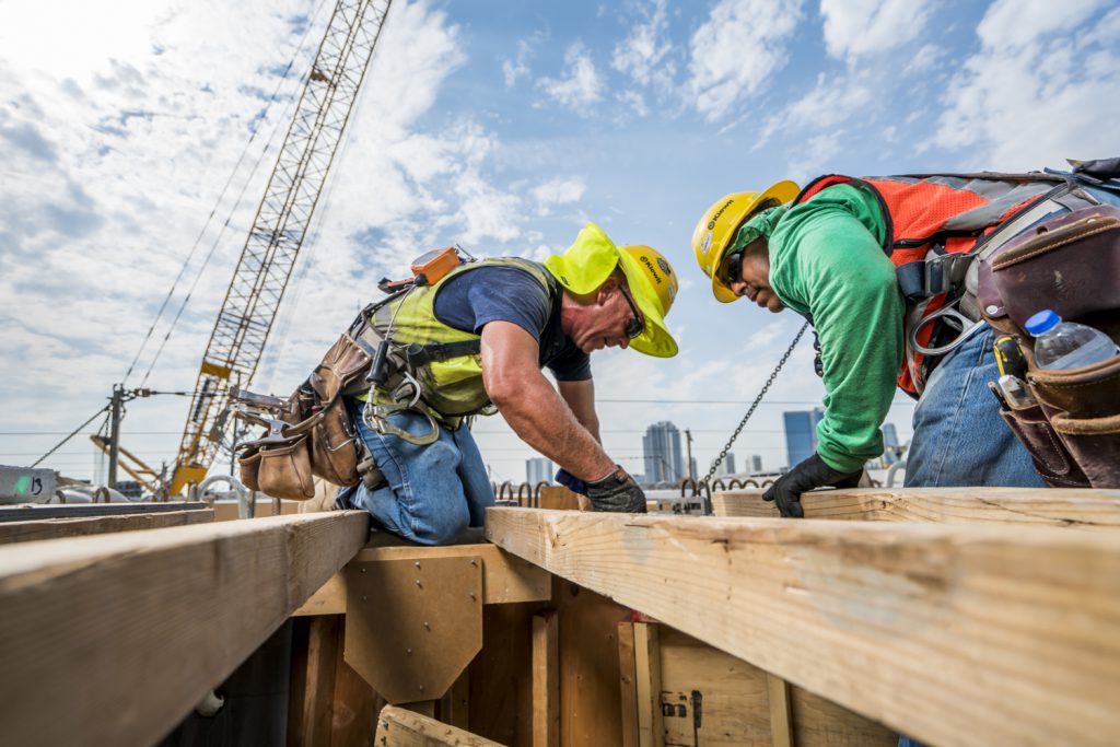 Carpenters build formwork for a cast-in-place  soffit.