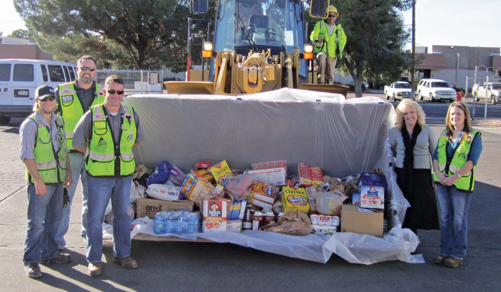 VTC employees with a bucketful of food collected during one of the many food drives throughout construction.