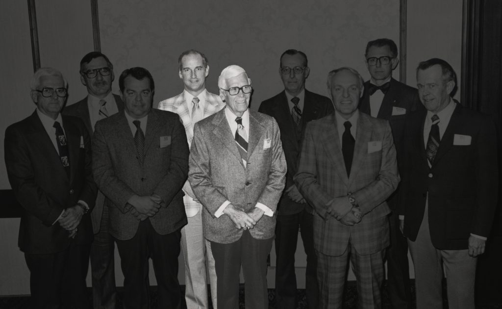 Walter stands behind Peter Kiewit in this photo taken at Annual Meeting in 1979.