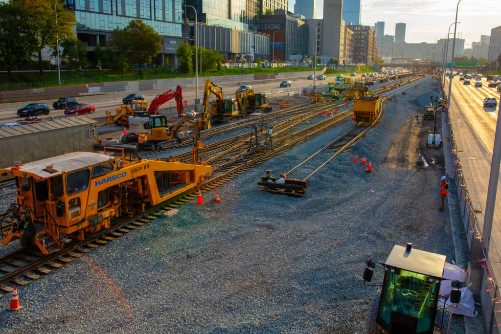 A tamping machine is used to align and compact the ballast underneath the railroad ties, keeping commuters' rides smooth.